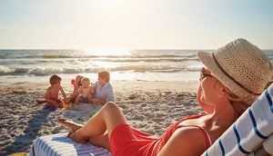 Person in straw hat looking at kids playing on the Lavallette beach